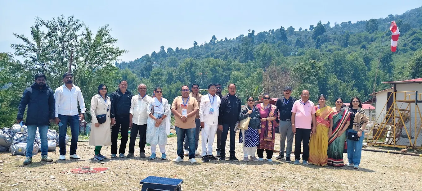 Group photo at the helipad amid green hills